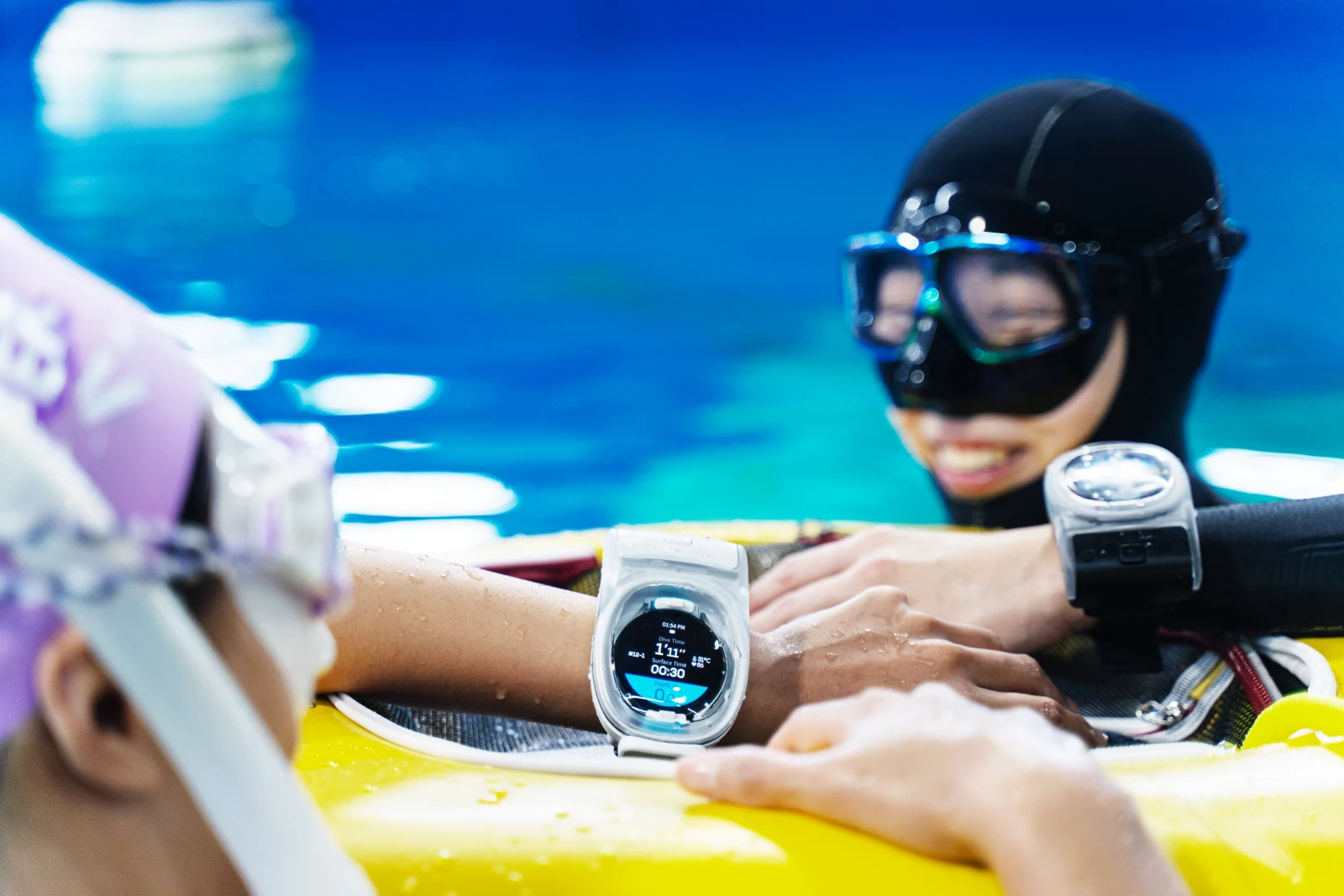 Freedivers checking WatchDive on their wrists at the surface