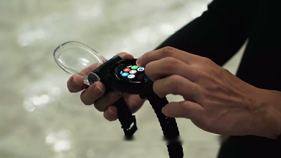 Hands placing a smartwatch into the WatchDive housing