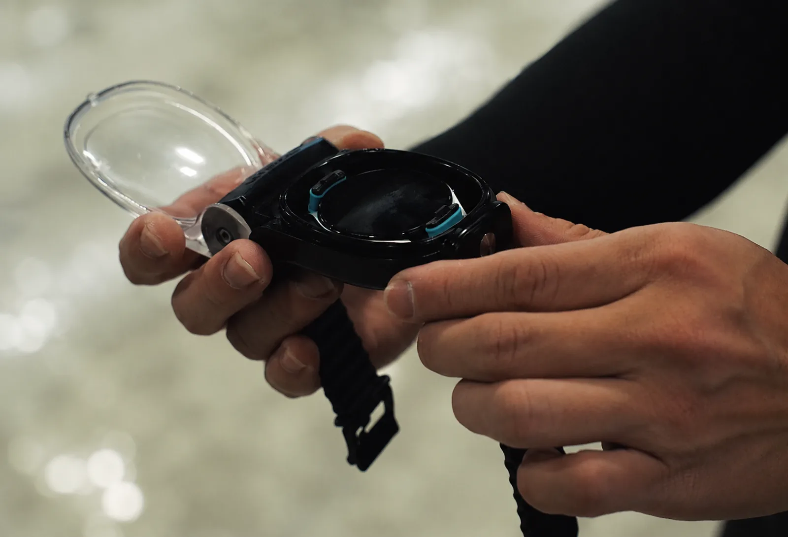 Hands placing a smartwatch into the Watch Dive housing